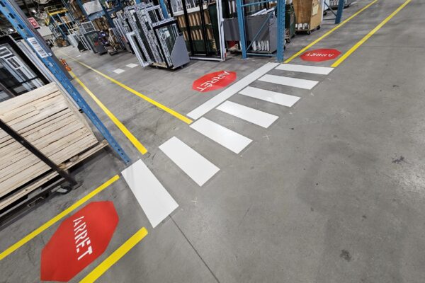 Passage piéton et signal d'arrêt en entrepôt.