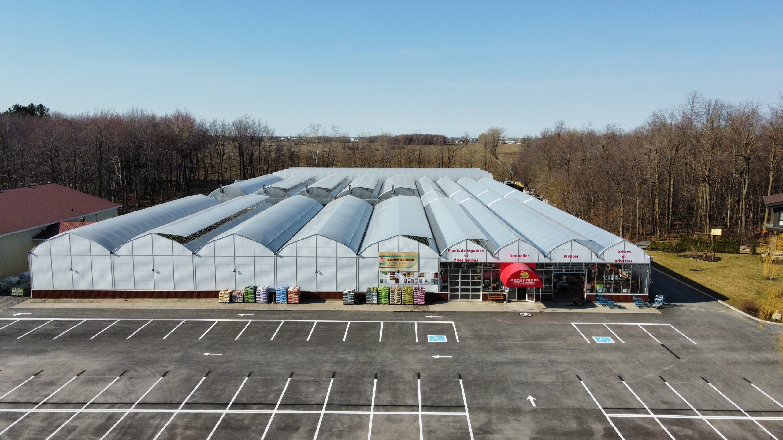 Grande serre moderne avec un parking vide.