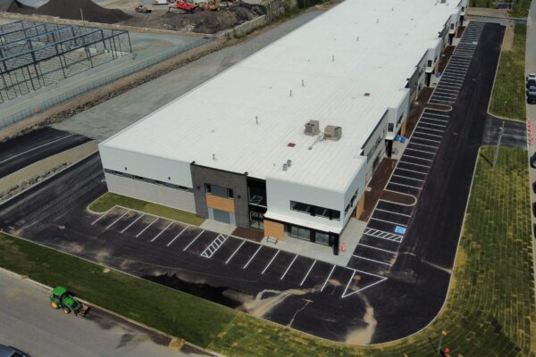 Vue aérienne d'un entrepôt moderne et parking aménagé.