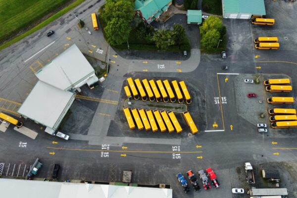 Vue aérienne d'un parking de bus scolaires jaunes.
